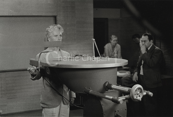 Chaplin, out of costume, rehearses the famous feeding machine sequence