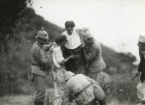 Chaplin getting into his tree costume on the set of Shoulder Arms