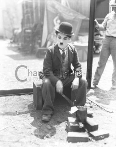 Charlie eating near wagon - close up - Charlie Chaplin Image Bank